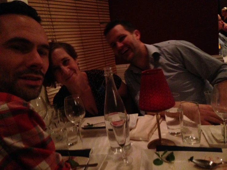 people sit at a table with empty wine glasses