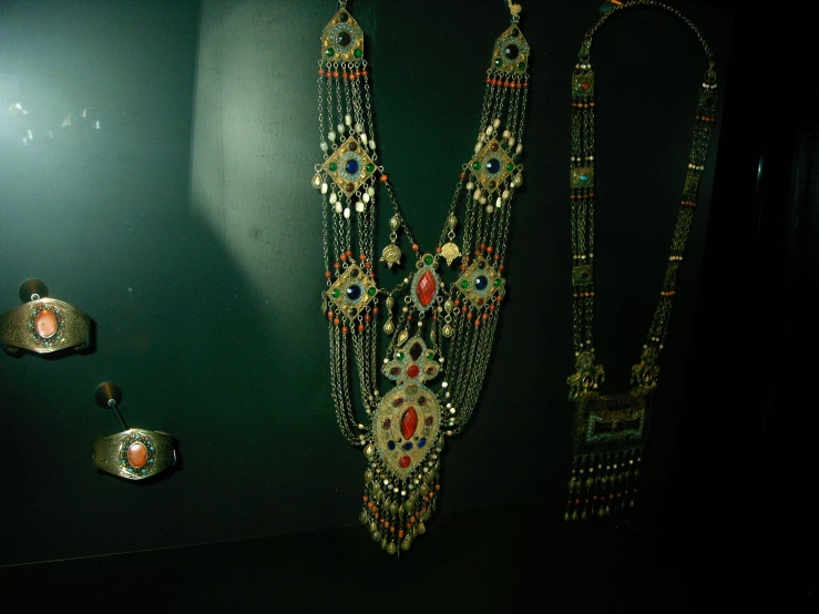 a variety of necklaces sit on display at a museum