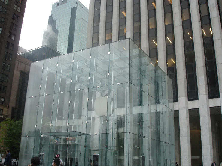 people walking outside an office building near large stone and glass windows