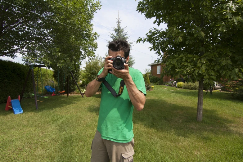 a man taking pictures in his backyard using a camera