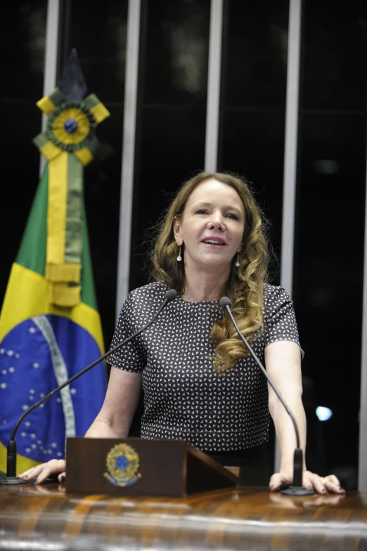 a woman in black and white shirt next to two flags