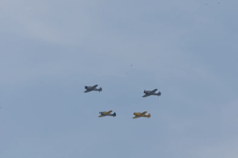 a group of four planes flying across the sky
