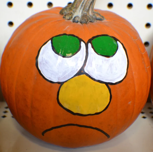 a pumpkin with faces painted on it and eyes