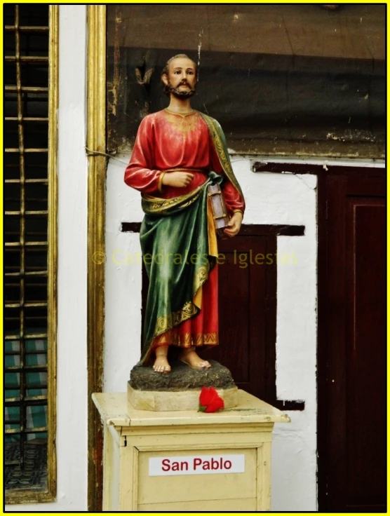 a statue on a pedestal holding a newspaper