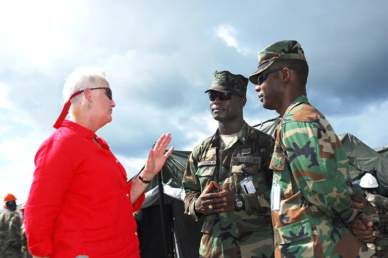 three military men are talking to a woman