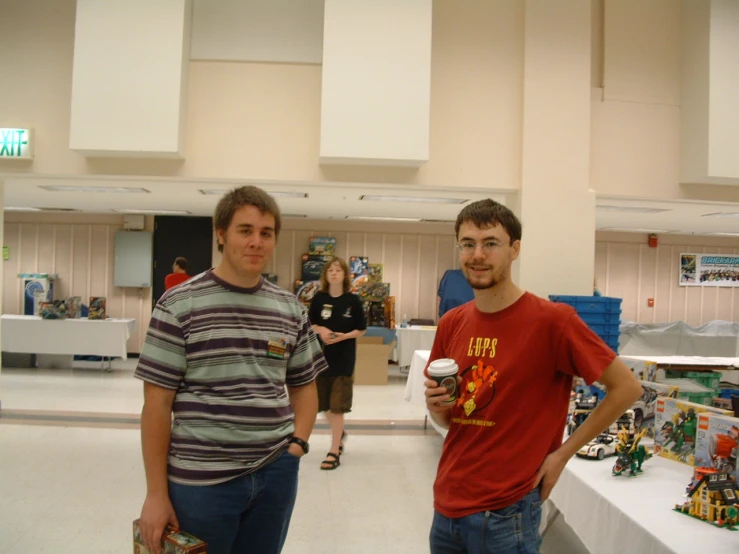 two men stand next to each other with toys on the tables