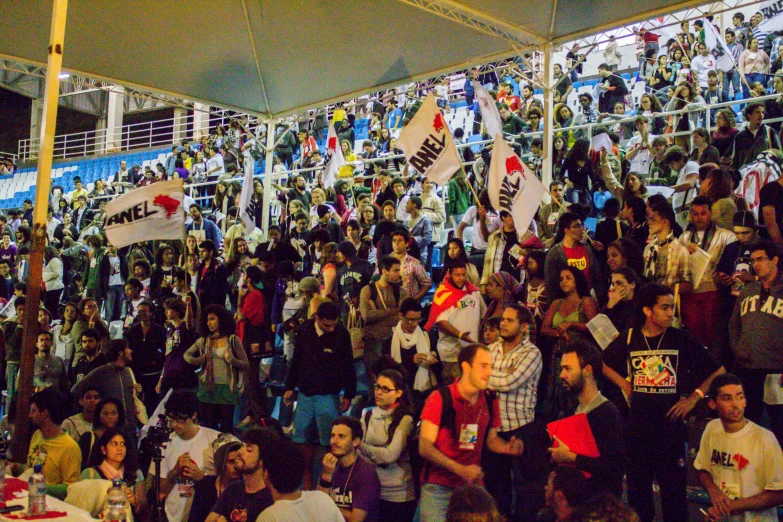 large group of people in building with posters and pictures on wall