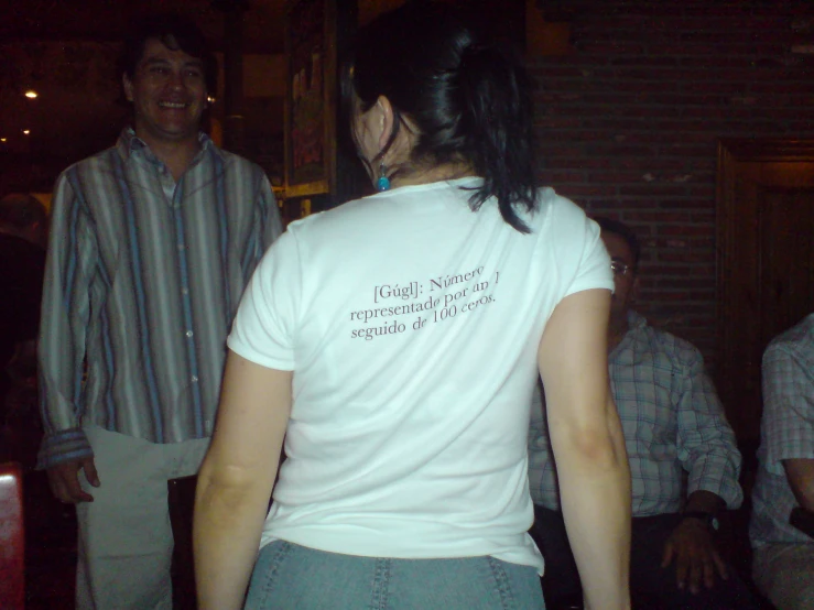 a woman wearing a white shirt has a message on the back