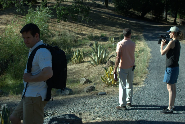 man taking pograph of woman and cactus with camera