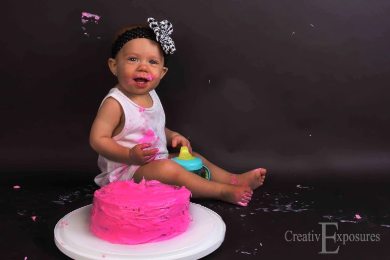a baby is sitting on a cake with sprinkles