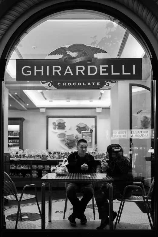 a couple is sitting outside in a chocolate shop