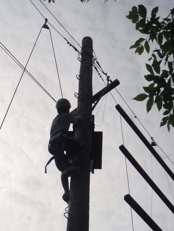 a man is climbing up an electrical pole