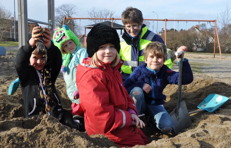 s in sand with shovels at the park