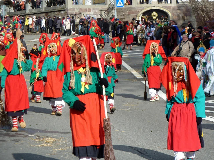 people wearing colorful costumes at a parade on the street