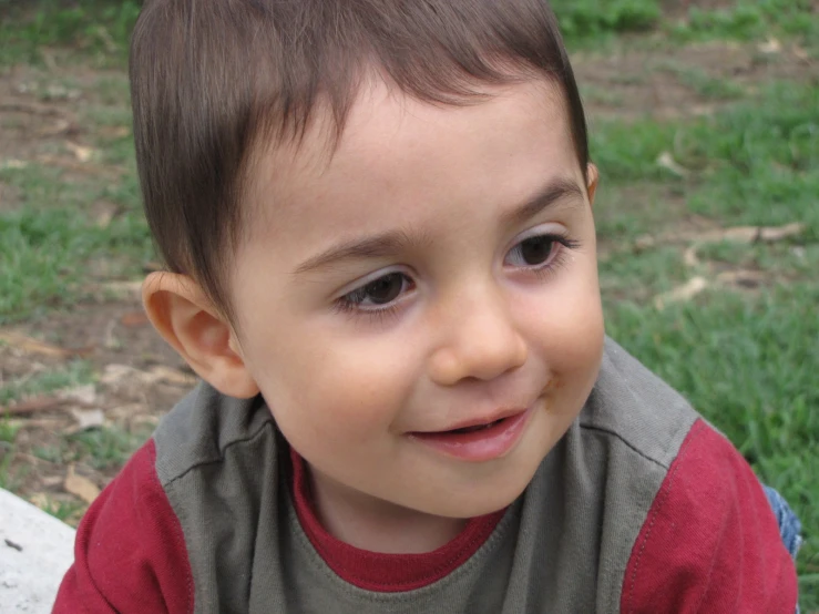 a child with brown hair and a red shirt