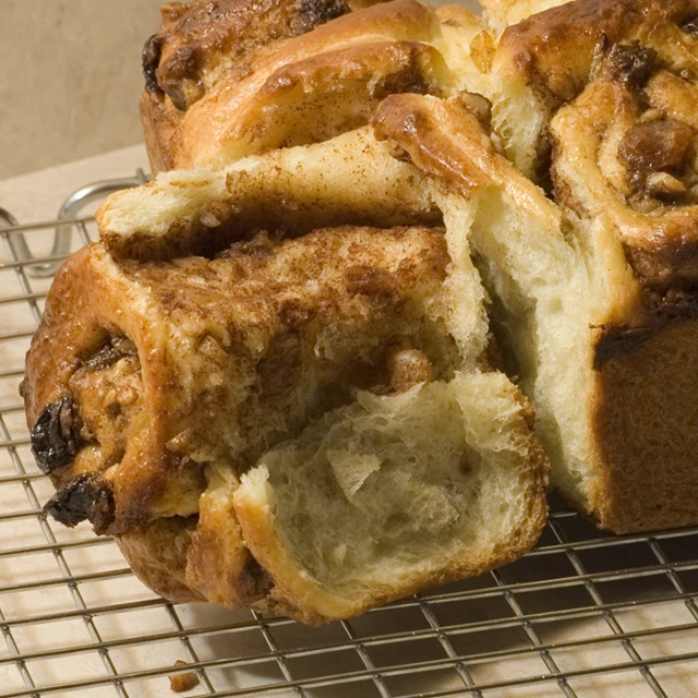 a loaf of bread is sliced on a cooling rack