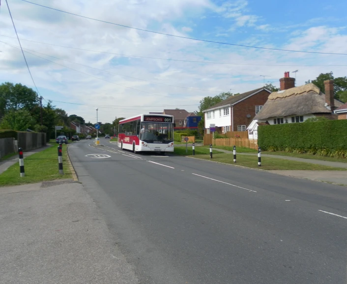 the bus is driving down the street in the daytime