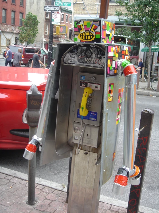 a coin phone sitting next to a street