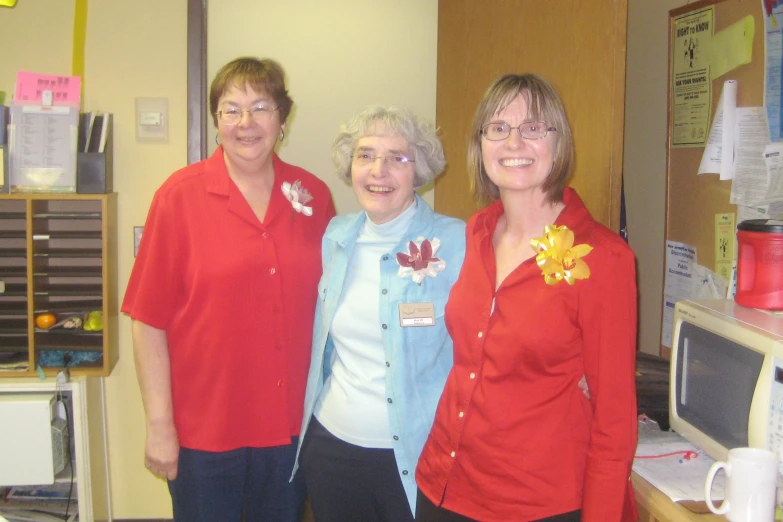 three woman standing next to each other wearing red shirt