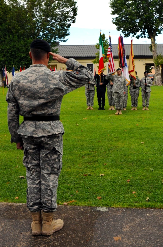 a soldier saluting soldiers from a group of men