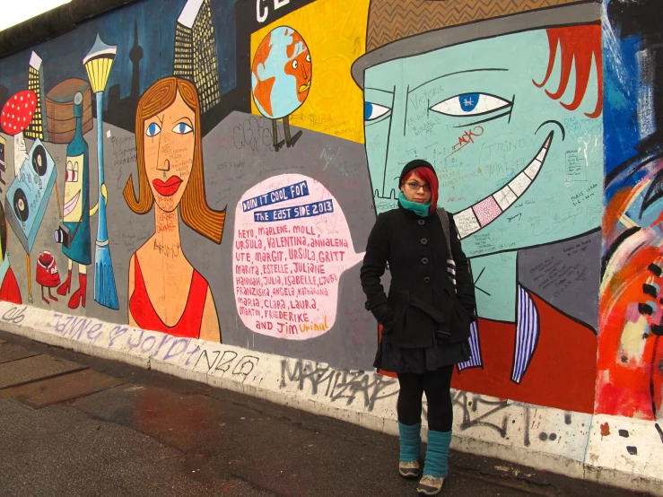 a girl in front of a wall with graffiti