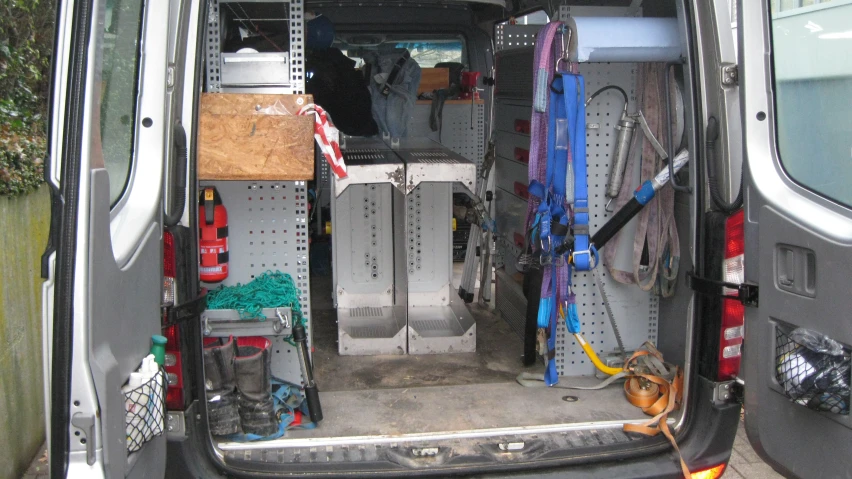a van is parked in a driveway, filled with equipment