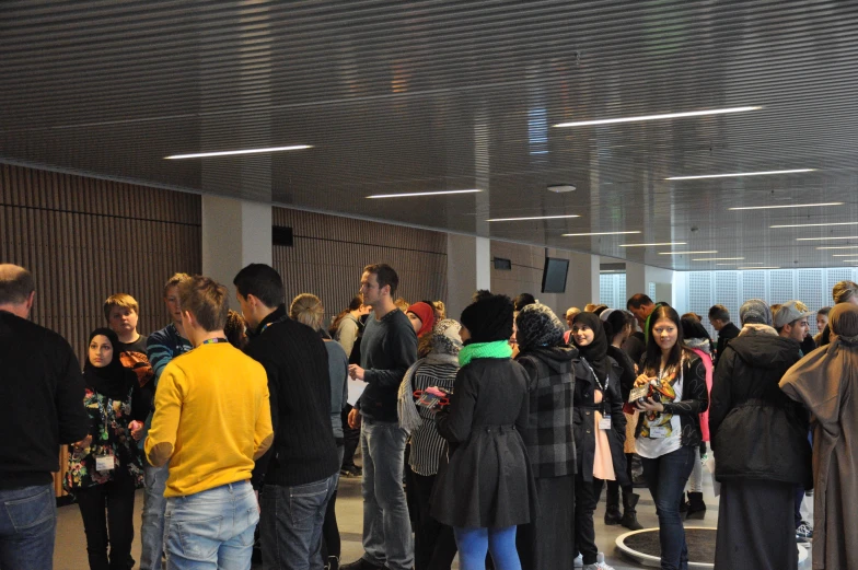 a group of people standing around looking at their cell phones