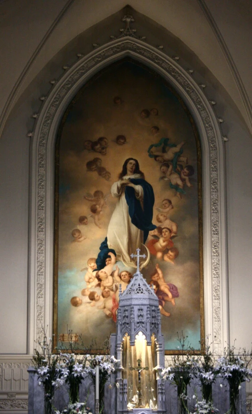 a cross inside of a building with a painting above it