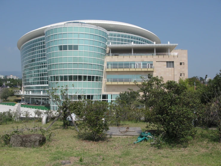 a very large round building sitting on top of a lush green hillside