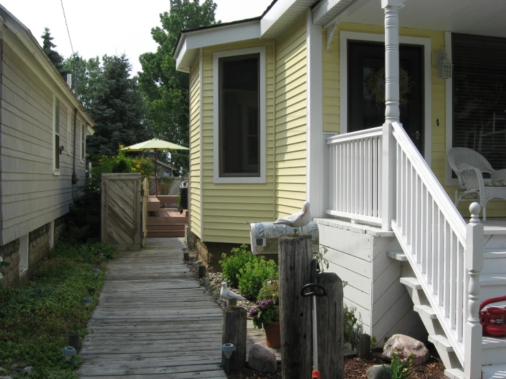 a front porch of a house with a door, steps and other small houses in the background