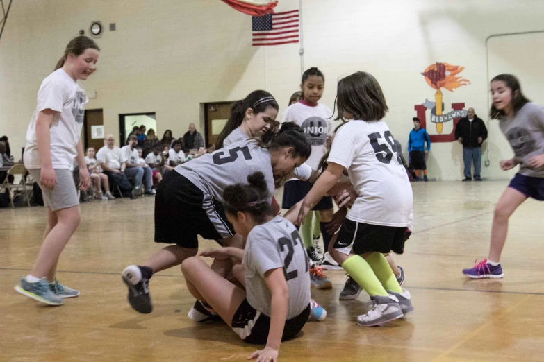 several young children play basketball with their coach