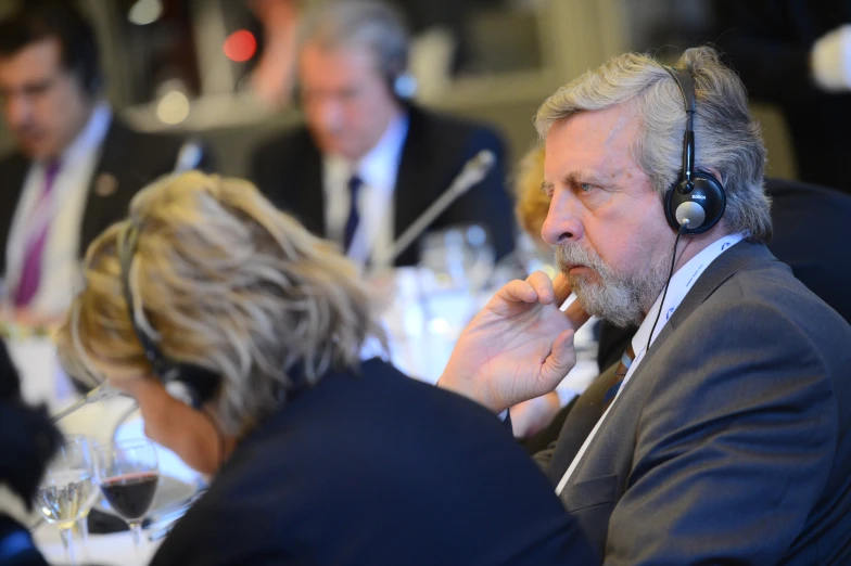 a man with headphones eating and other people