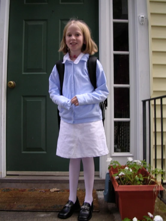 a little girl stands in front of her front door