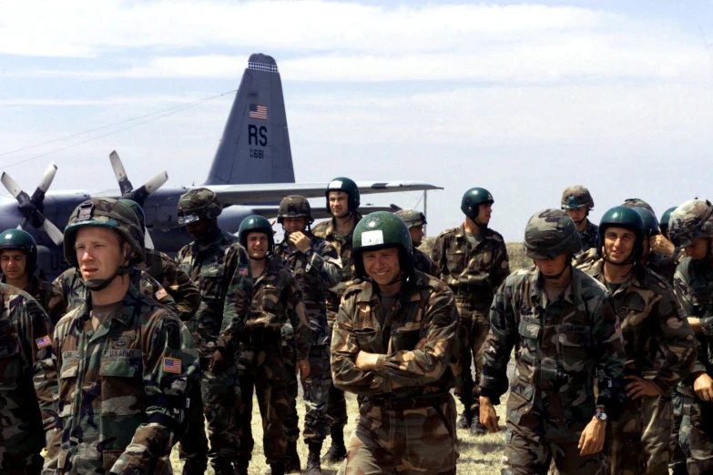 military personnel standing in front of a fighter jet