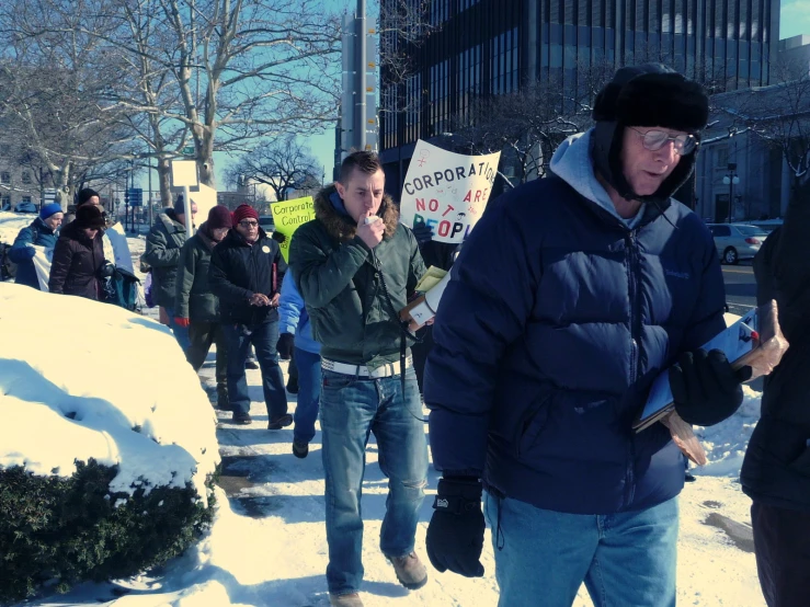 a man stands in the middle of snow while some people stand by