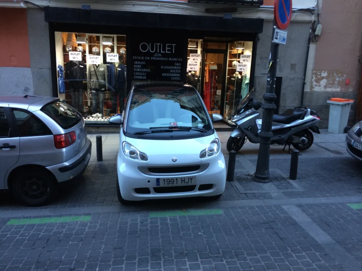 a small car that is parked next to a pole