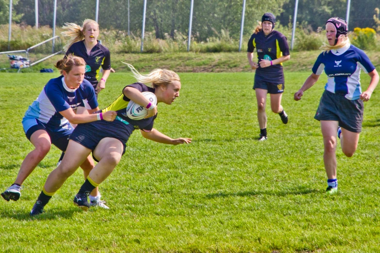 young women are playing soccer together in the field