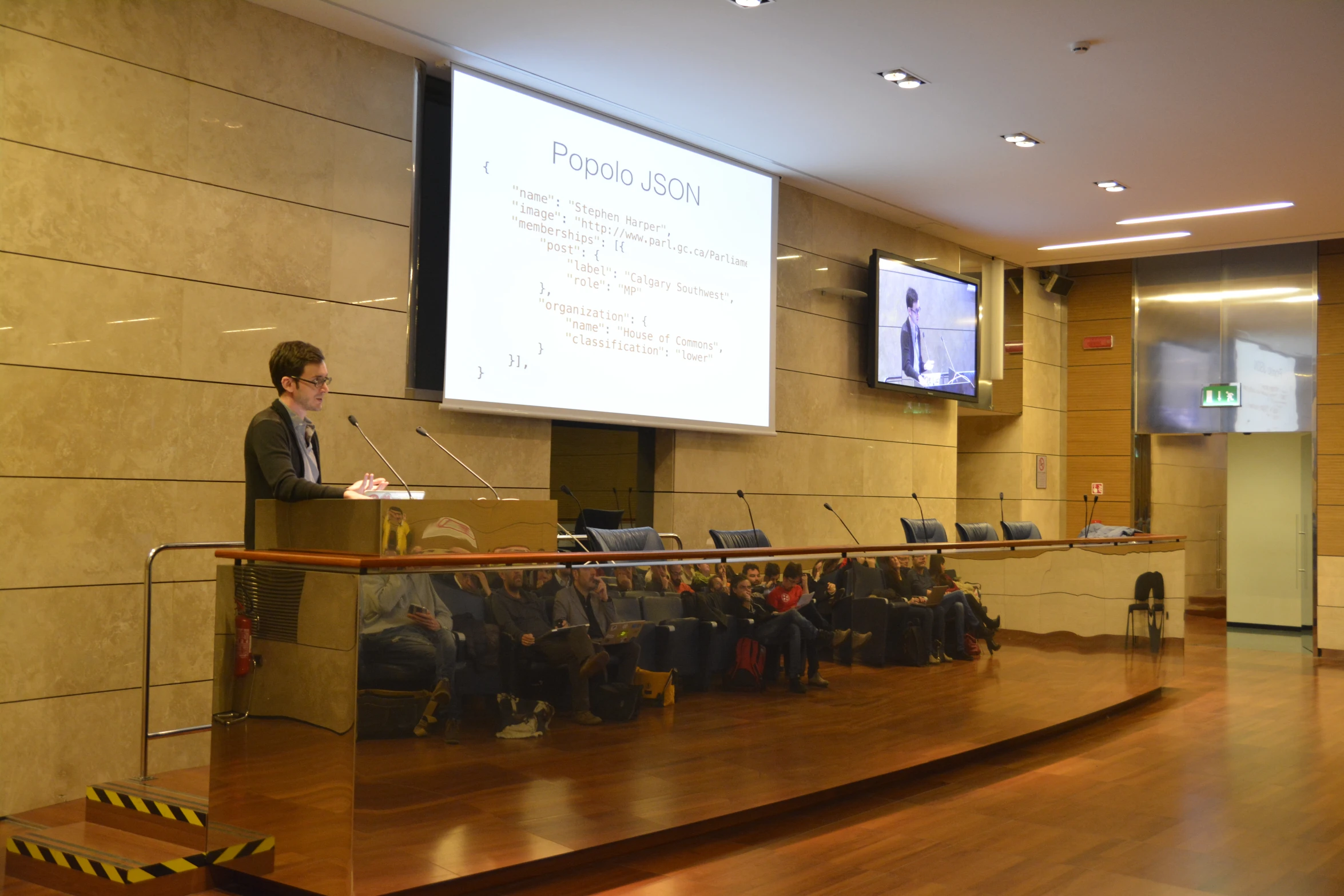 a man is standing at a podium behind an audience