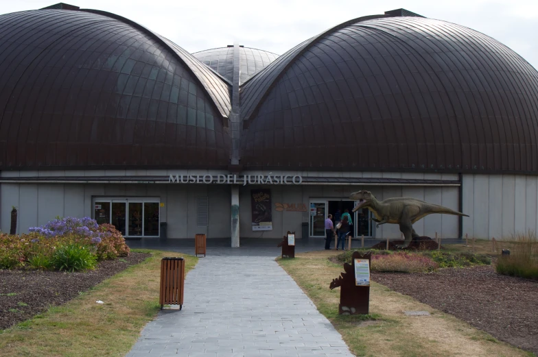 two large brown domed buildings with grass and rocks