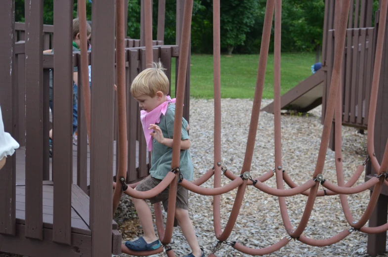 young children playing in a wooden play yard