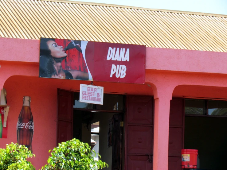 signs hang on the pink building at banana pub