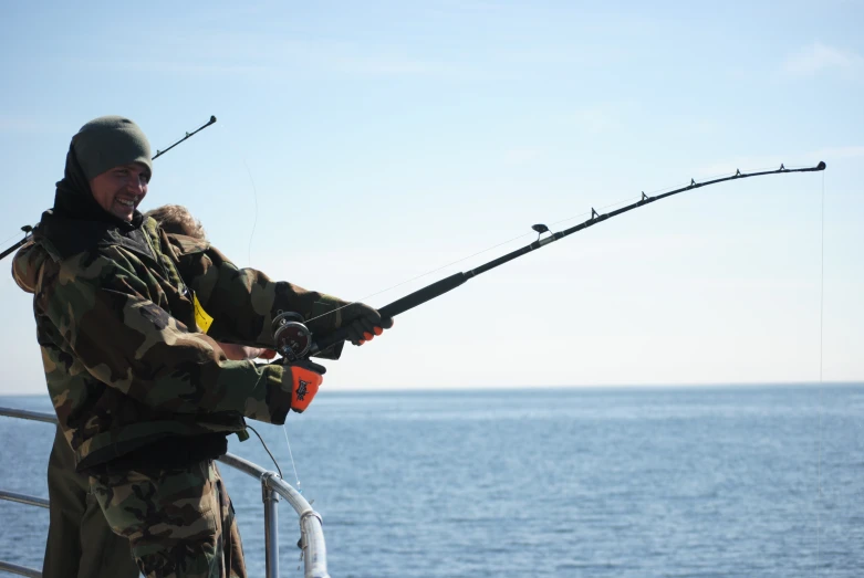 man with fishing pole on boat in body of water