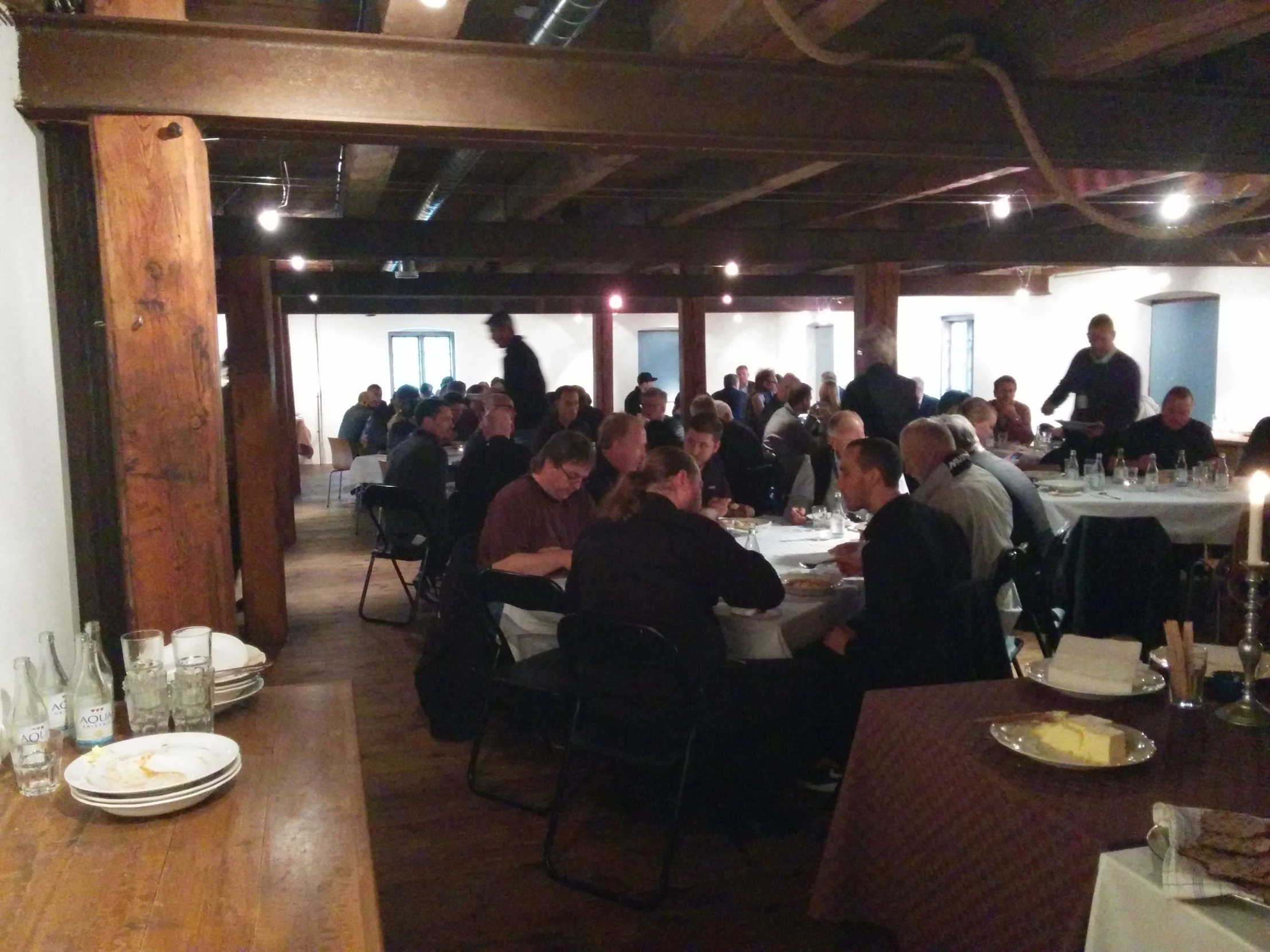 a large number of people sit around tables eating