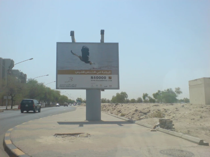 a billboard on the side of a road with two birds in flight