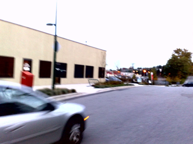 a white car driving down a city street