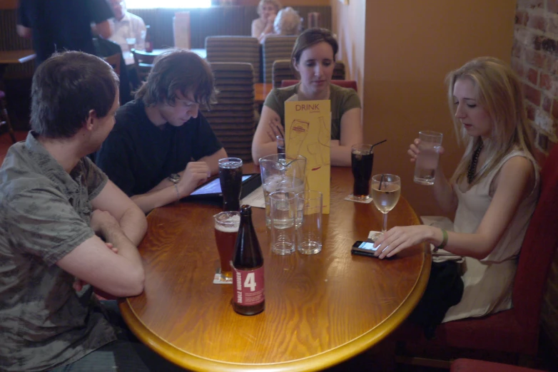 people sitting at a table with empty beers