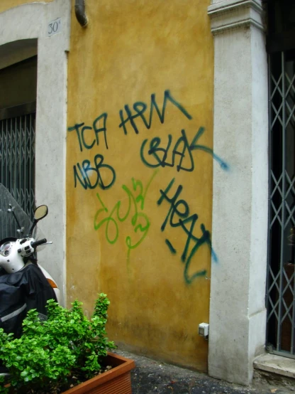 a motor bike parked next to a wall with graffiti