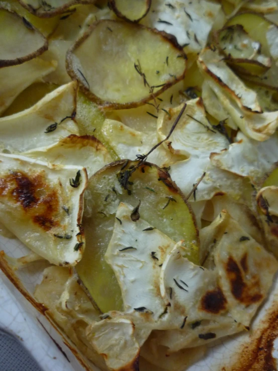 an oven dish covered with potato chips, herbs and garlic