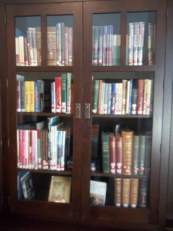 an empty wooden case holds several books in it