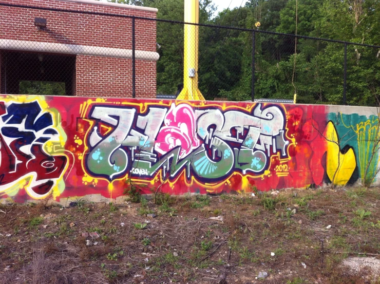 an area that is covered with graffiti and has a yellow pole in the background